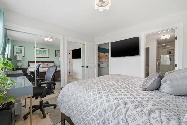 a bedroom with a bed and a flat screen tv