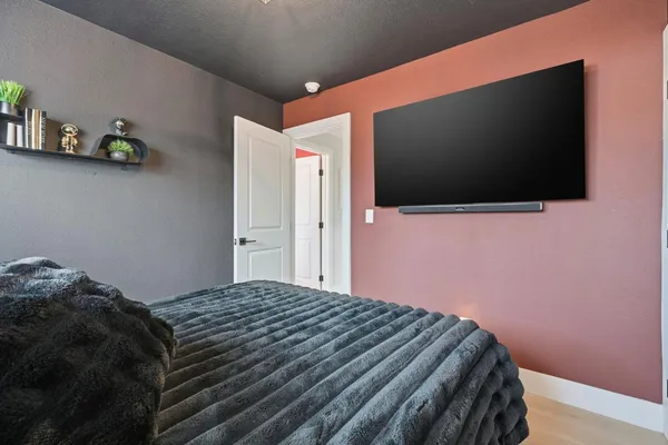 a bedroom with a bed and a flat screen tv