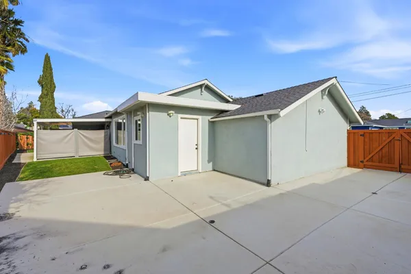 a view of an house with backyard and parking space
