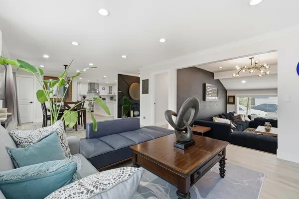 a living room with furniture a dining table and a chandelier