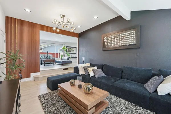 a living room with furniture a chandelier and a rug