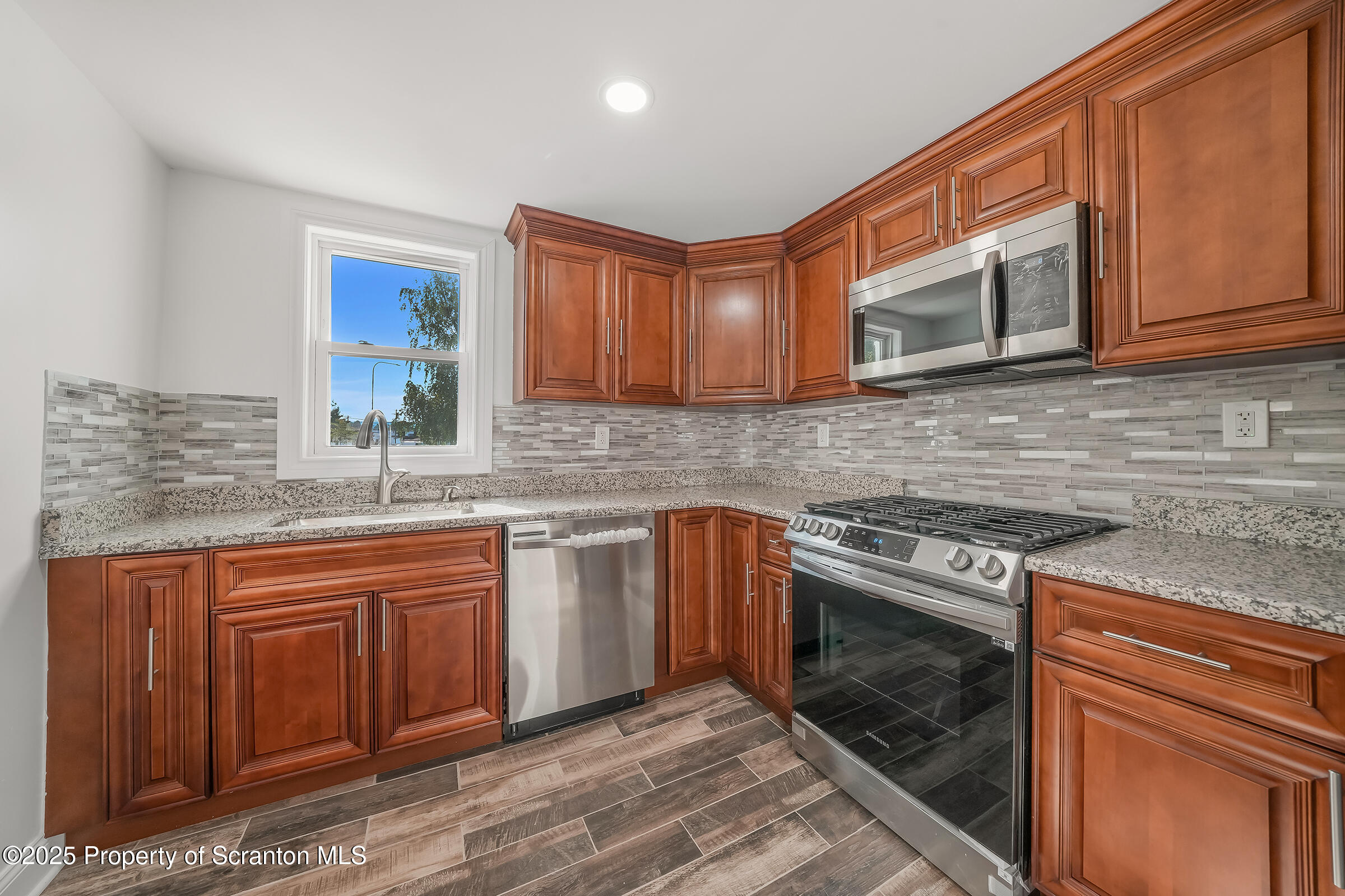 1017 Rutter Avenue Kingston, PA 18704 - Photo 14 of 36 a kitchen with stainless steel appliances granite countertop wooden cabinets stove top oven and sink