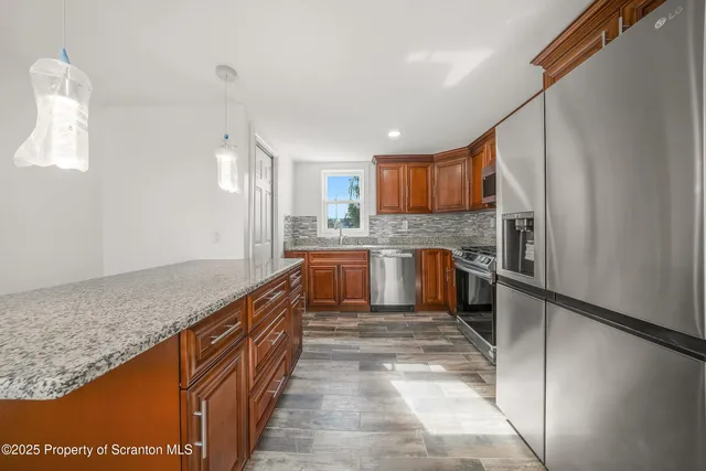 a kitchen with stainless steel appliances granite countertop a stove top oven a sink and dishwasher