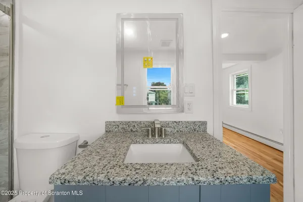 a bathroom with a granite countertop sink and a mirror