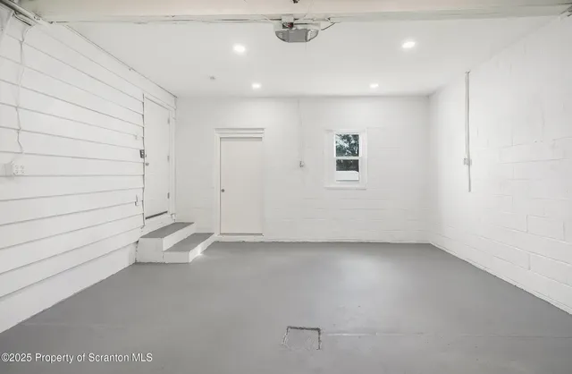 an empty room with a ceiling fan and windows