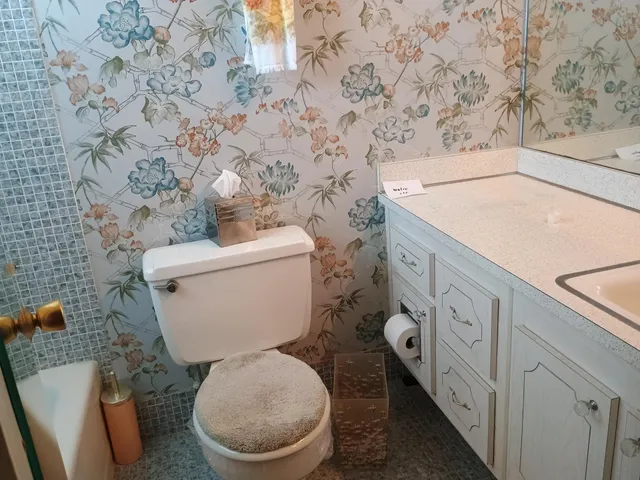 a white toilet sitting next to a shower