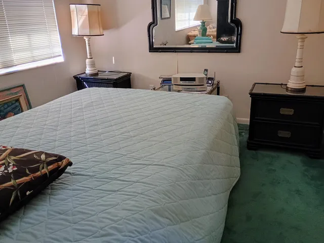 a bedroom with a bed and a lamp on dresser