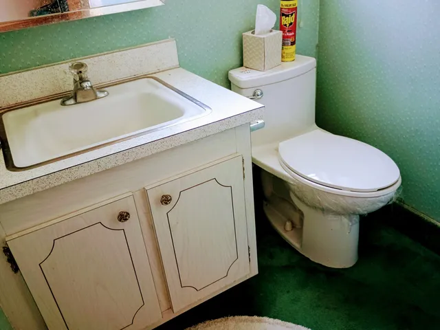 a bathroom with a sink mirror vanity and toilet