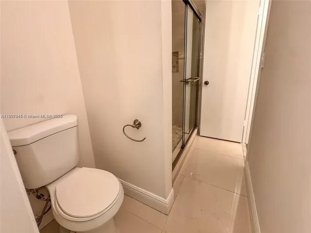 a white toilet sitting next to a shower