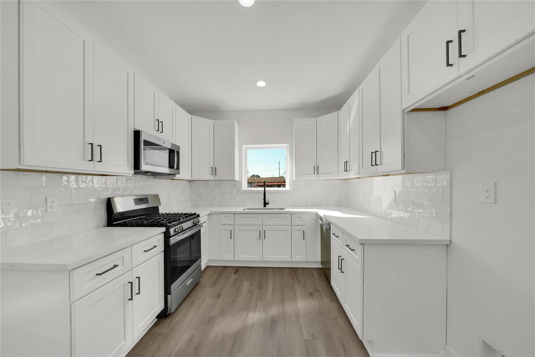 8402 Double, Unit B Houston, TX 77088 - Photo 4 of 21 a kitchen with granite countertop white cabinets and white appliances