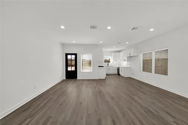 a view of a big room with wooden floor and windows