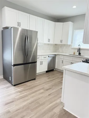 a kitchen with a refrigerator sink and cabinets