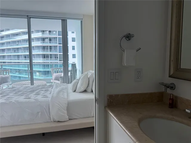 a bedroom with a bed and a large window