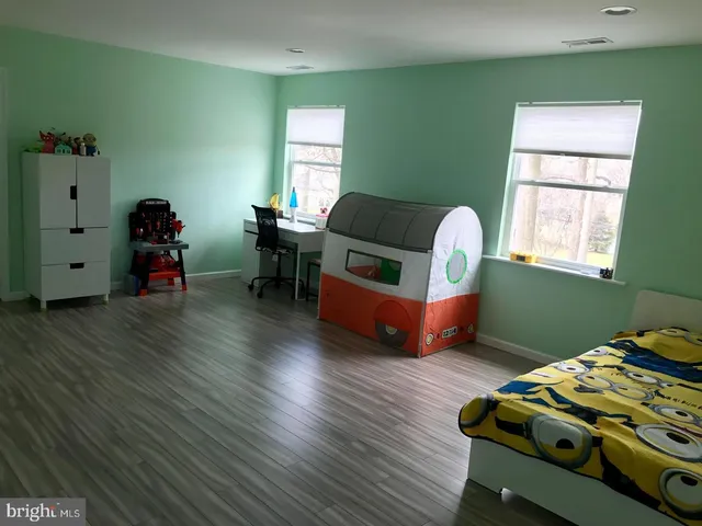 a bedroom with furniture and a wooden floor