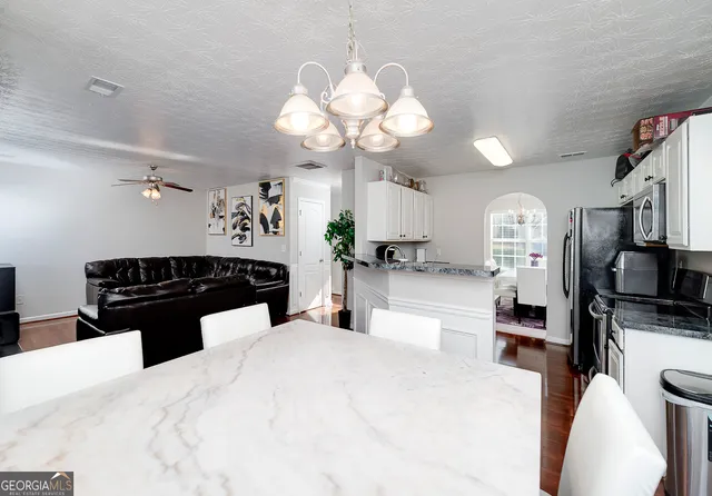 a kitchen with a refrigerator a sink dishwasher a stove and white cabinets with wooden floor