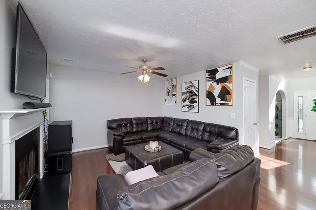 a black leather couch in living room with a flat screen tv