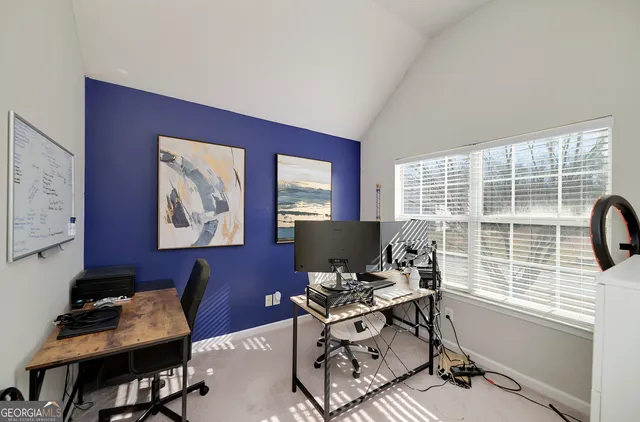 a view of a workspace with furniture and a window