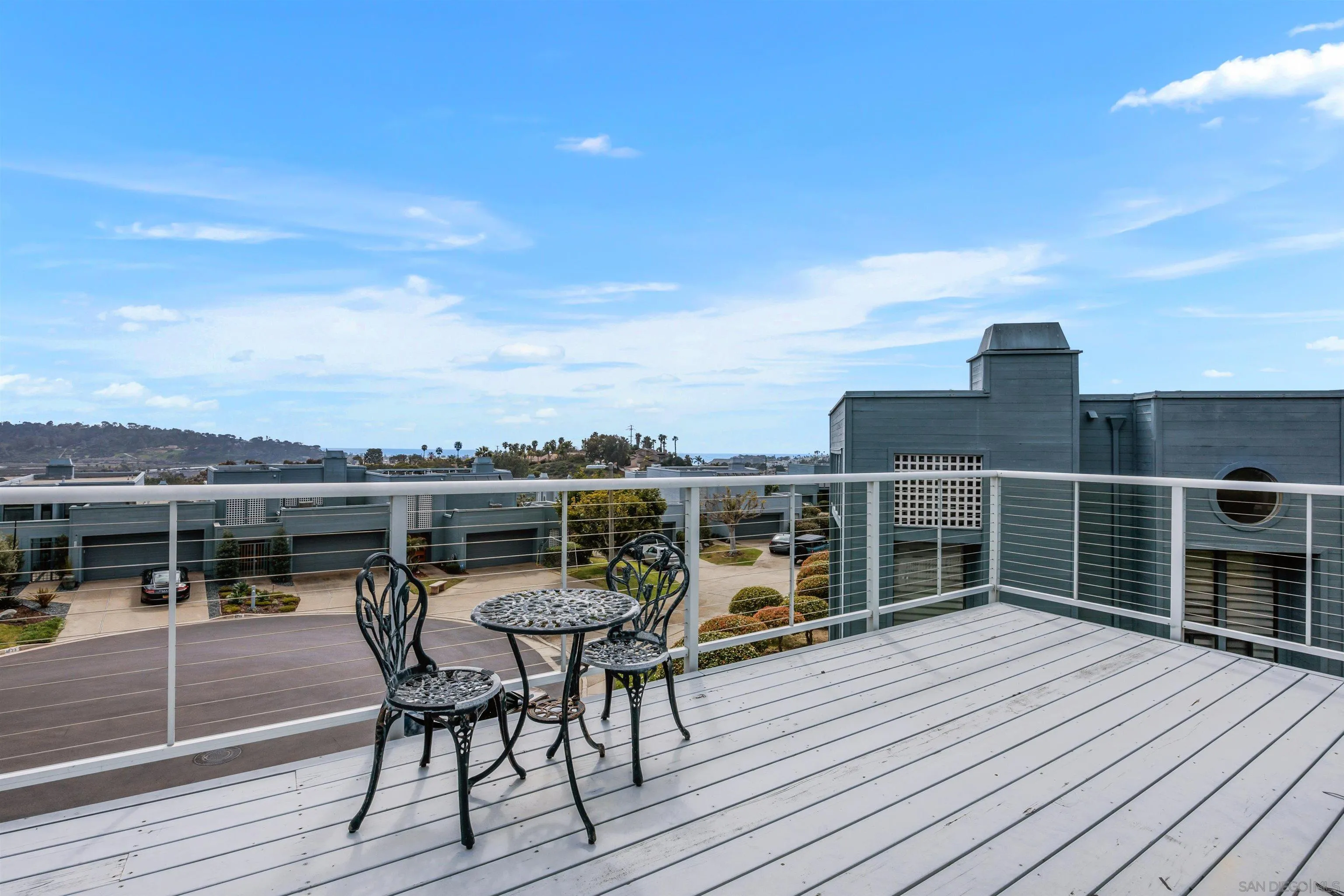 1046 America Way Del Mar, CA 92014 - Photo 2 of 12 a view of a roof deck with table and chairs a barbeque with wooden floor and fence
