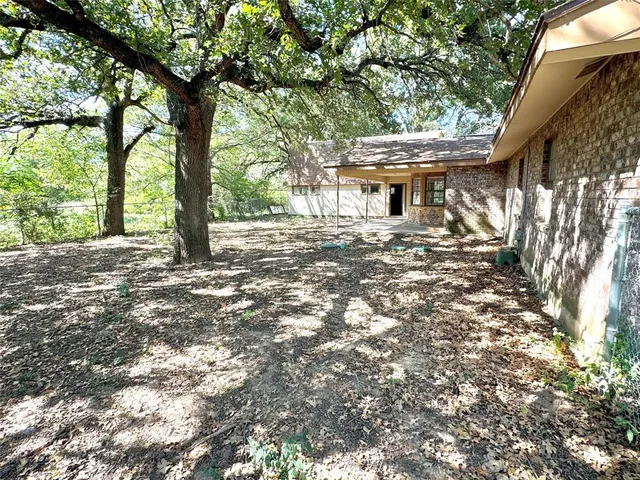a view of a house with a tree in front of it