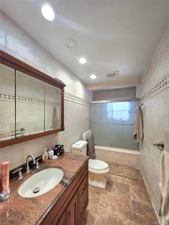 a bathroom with a double vanity sink toilet mirror and shower