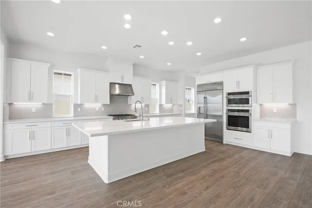 a large kitchen with stainless steel appliances granite countertop a stove and a sink