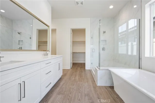 a spacious bathroom with a double vanity sink a mirror and a bathtub