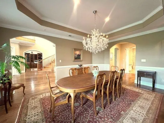 a view of a dining room with furniture a chandelier and wooden floor