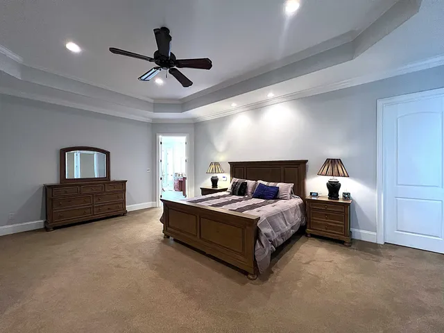 a spacious bedroom with a bed and a ceiling fan