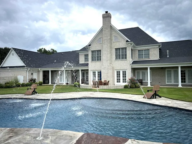 a view of a house with swimming pool and yard