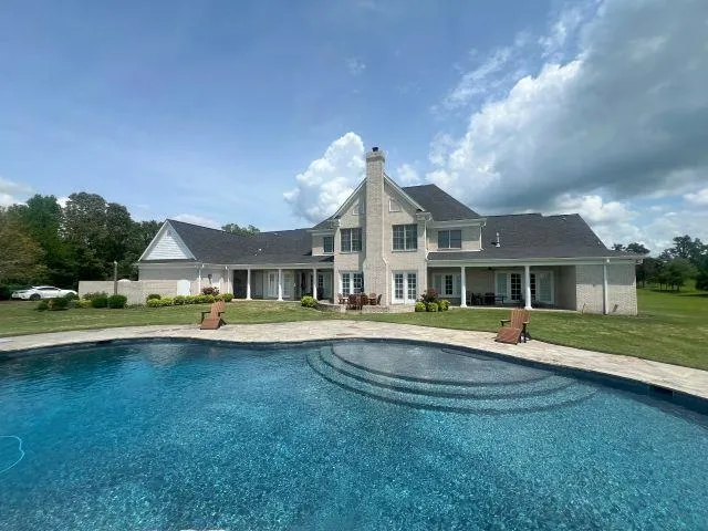 a view of a house with swimming pool and a yard