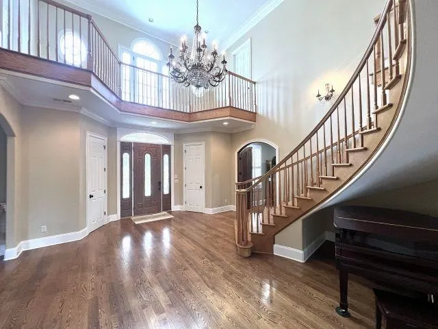 a view of a hallway with wooden floor and stairs