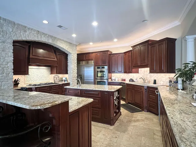 a kitchen with kitchen island granite countertop a sink and a stove