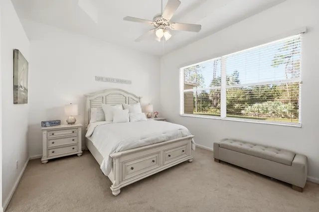 a bedroom with a bed chair and a large window