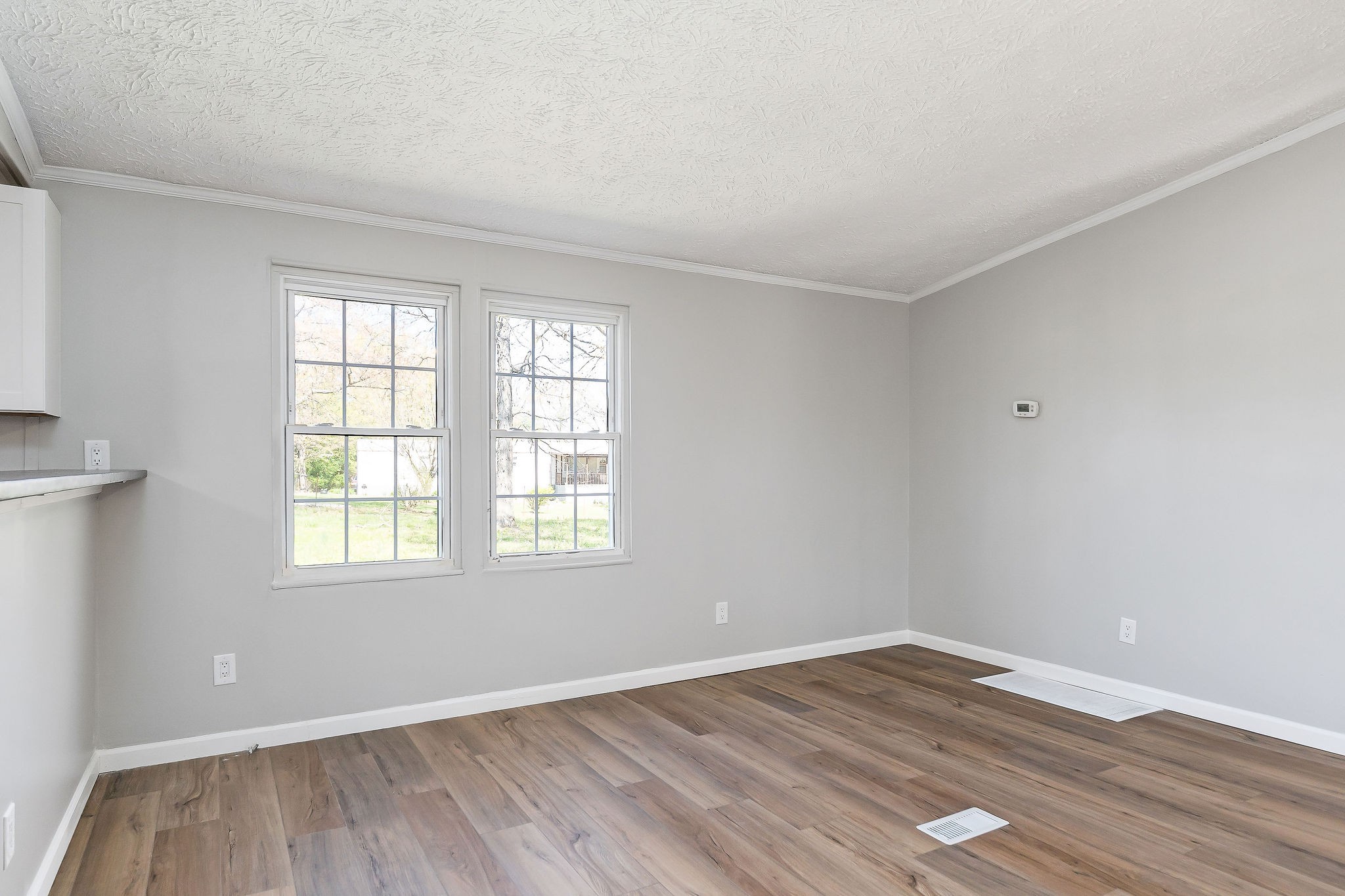 689 Capshaw Road Smithville, TN 37166 - Photo 6 of 29 an empty room with wooden floor and windows