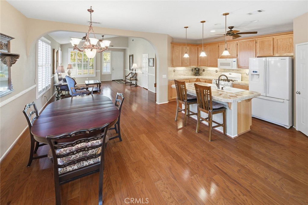 28920 Raintree Drive Menifee, CA 92584 - Photo 19 of 51 a dining room with wooden floor a chandelier a wooden table and chairs
