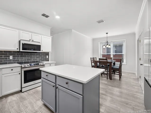 a kitchen with a stove cabinets and wooden floor