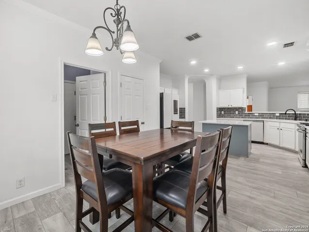 a view of a dining room and kitchen with a table chairs