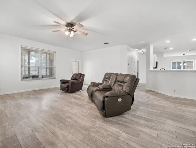a living room with furniture and a ceiling fan