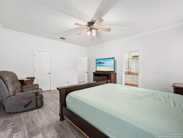 a bedroom with a bed a couch and a chandelier