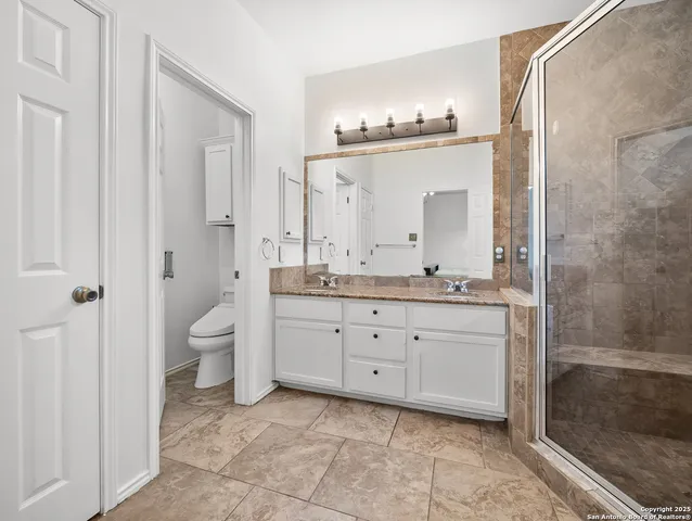 a spacious bathroom with a granite countertop sink a mirror and a bathtub
