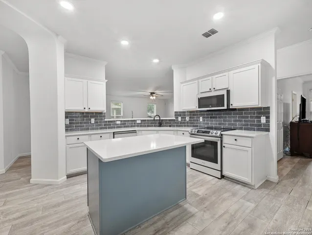 a kitchen with a sink stove a microwave and cabinets