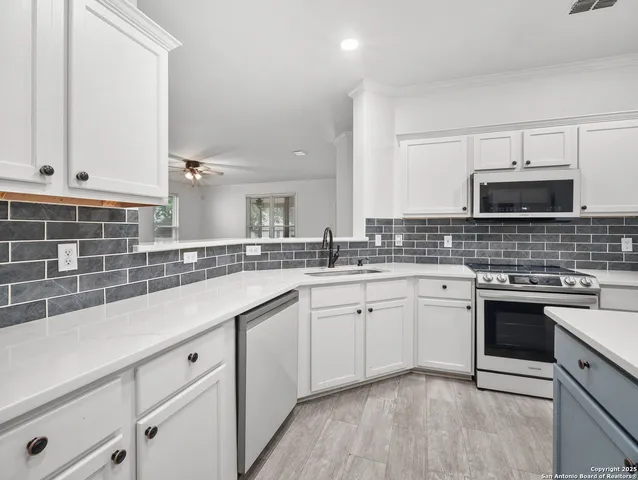 a kitchen with kitchen island granite countertop a sink cabinets and stainless steel appliances