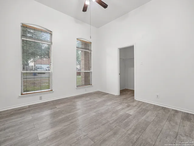 an empty room with wooden floor and windows