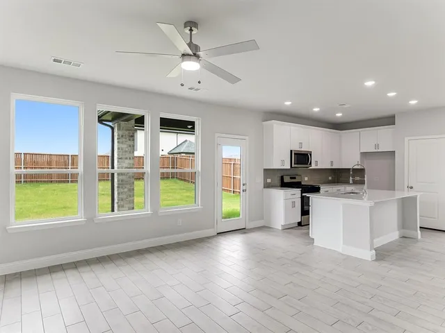 a view of kitchen with stove and cabinets