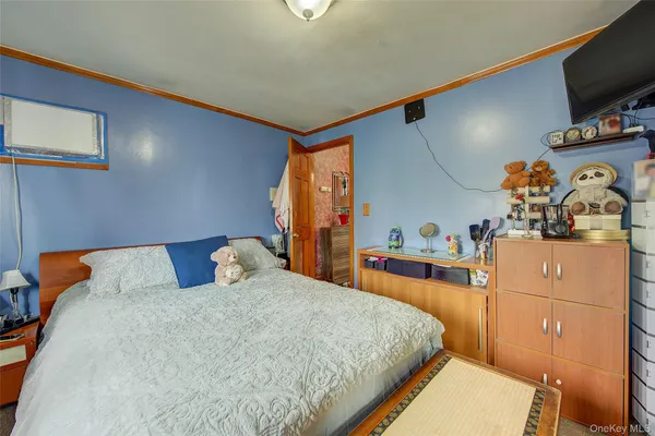 a bedroom with a bed and a flat tv screen on dresser