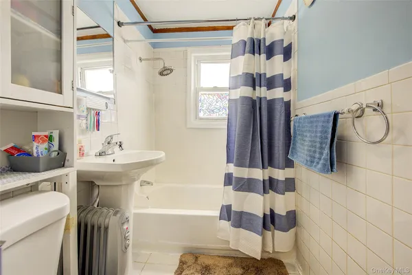 a bathroom with a sink a toilet and shower curtain