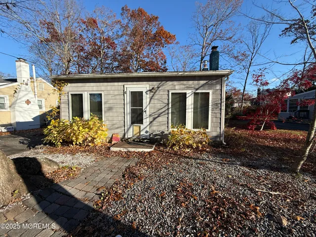 a view of a house with a small yard and potted plants