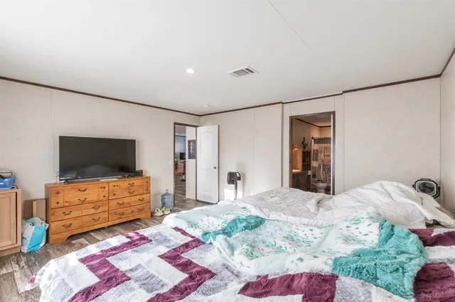 a bedroom with a bed and flat screen tv