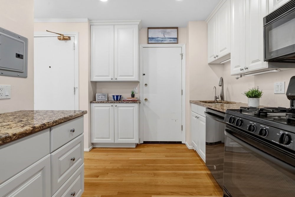 135 Granite Avenue, Unit 49 Boston, MA 02124 - Photo 6 of 14 a kitchen with granite countertop a stove and a sink