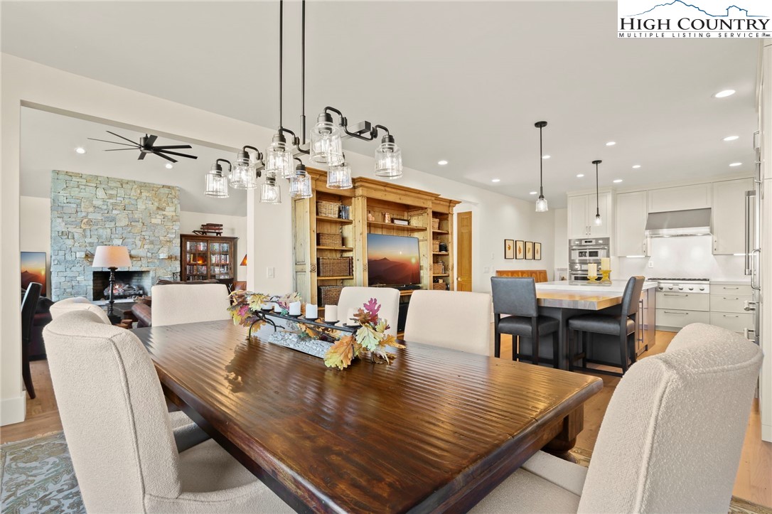 110 Pinnacle Ridge Road Beech Mountain, NC 28604 - Photo 15 of 49 a view of a dining room and livingroom with furniture wooden floor a rug a fireplace and a chandelier